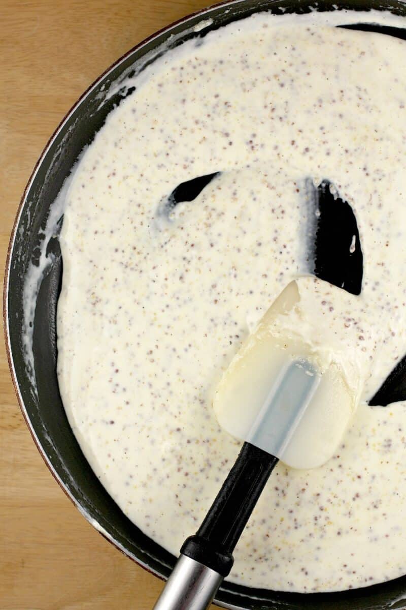 rubber spatula with mustard sauce in skillet