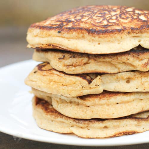 cinnamon applesauce pancakes stacked on white plate, side view