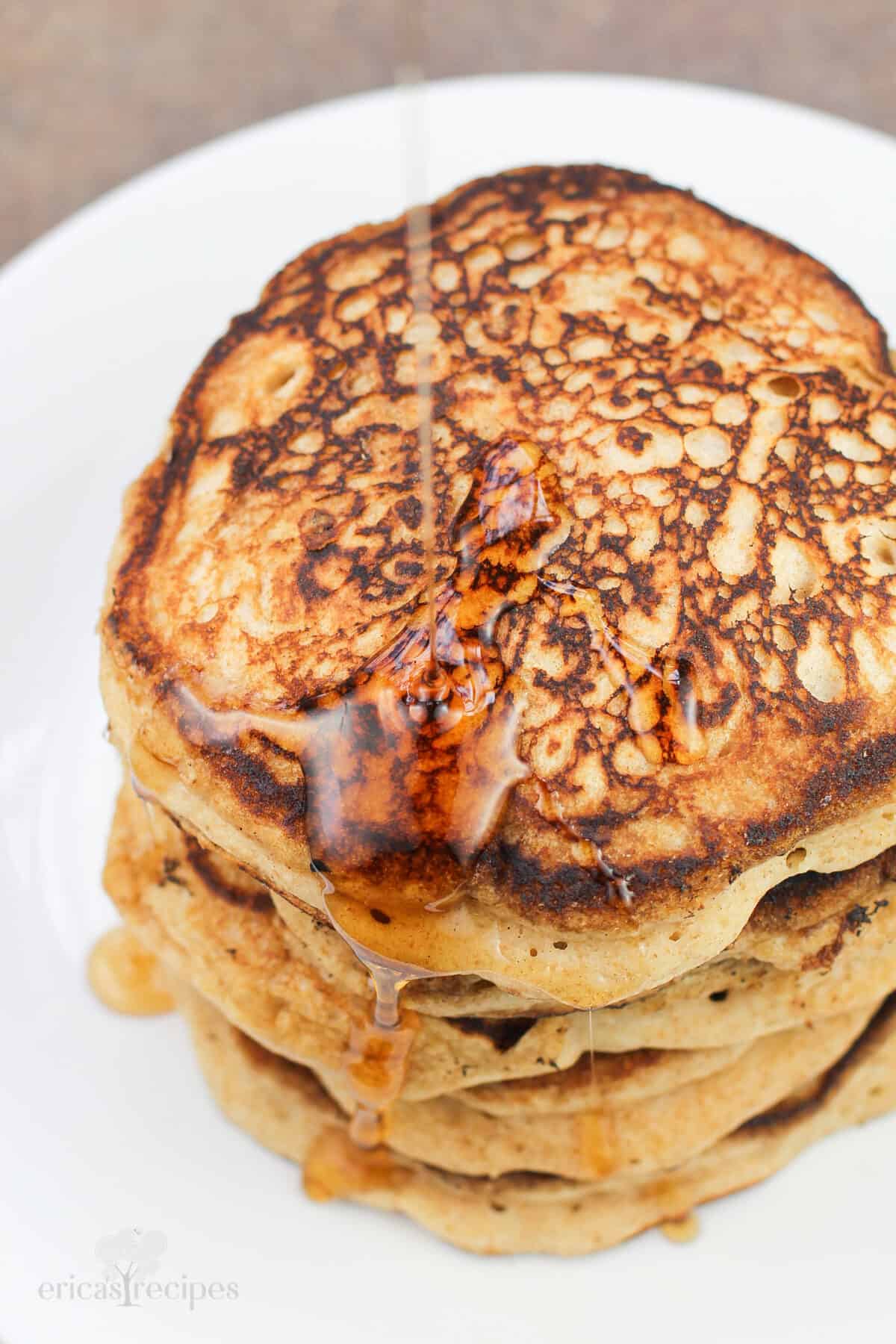 syrup pouring on stack of pancakes, top down view