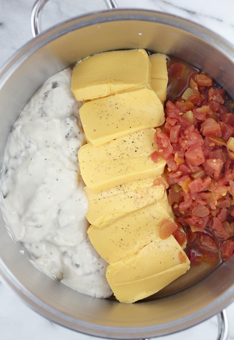 Cheese, condensed soup, and Rotel in a pot before heating