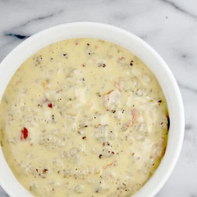 White bowl on marble surface, overhead view to show finished queso