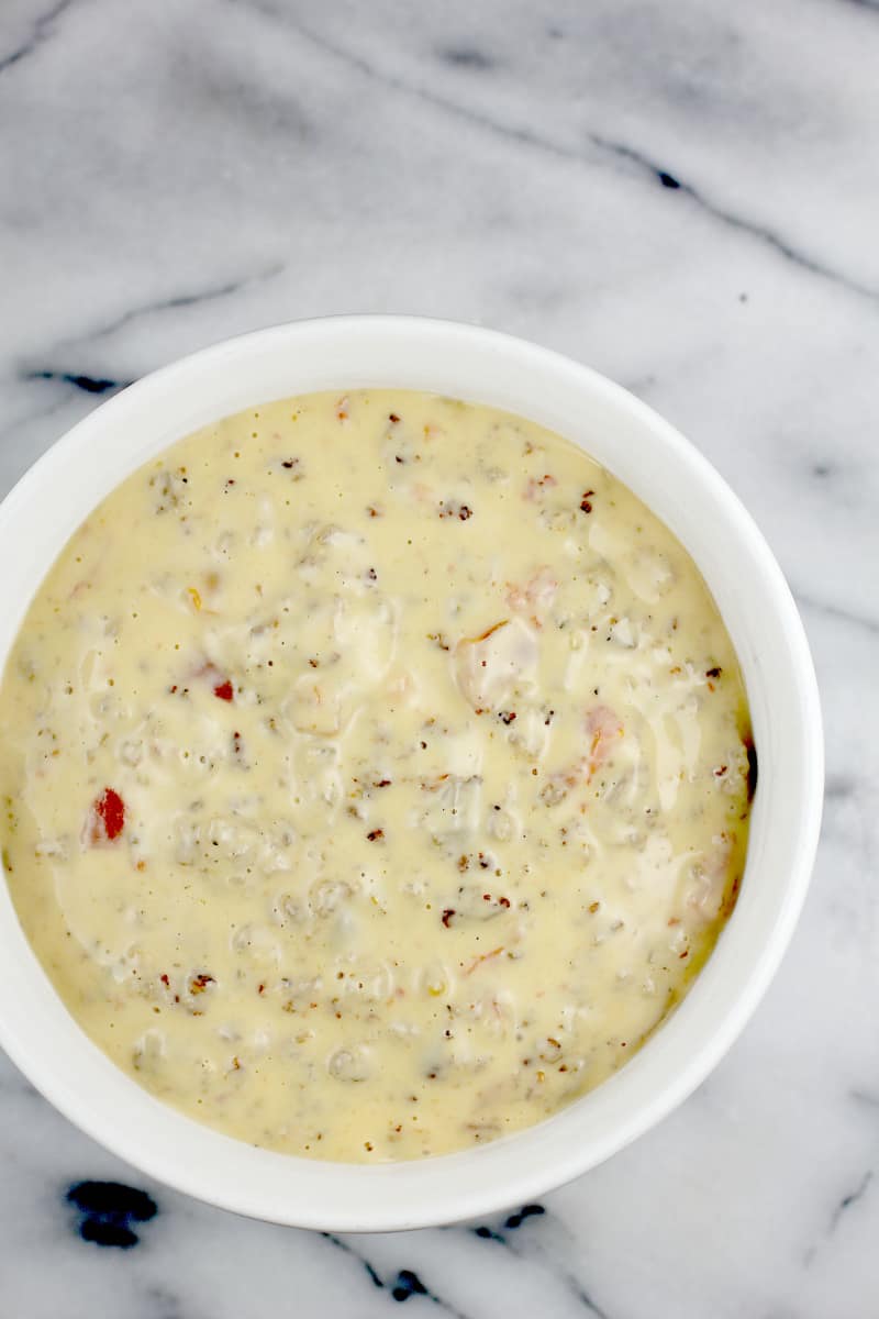 White bowl on marble surface, overhead view to show finished queso