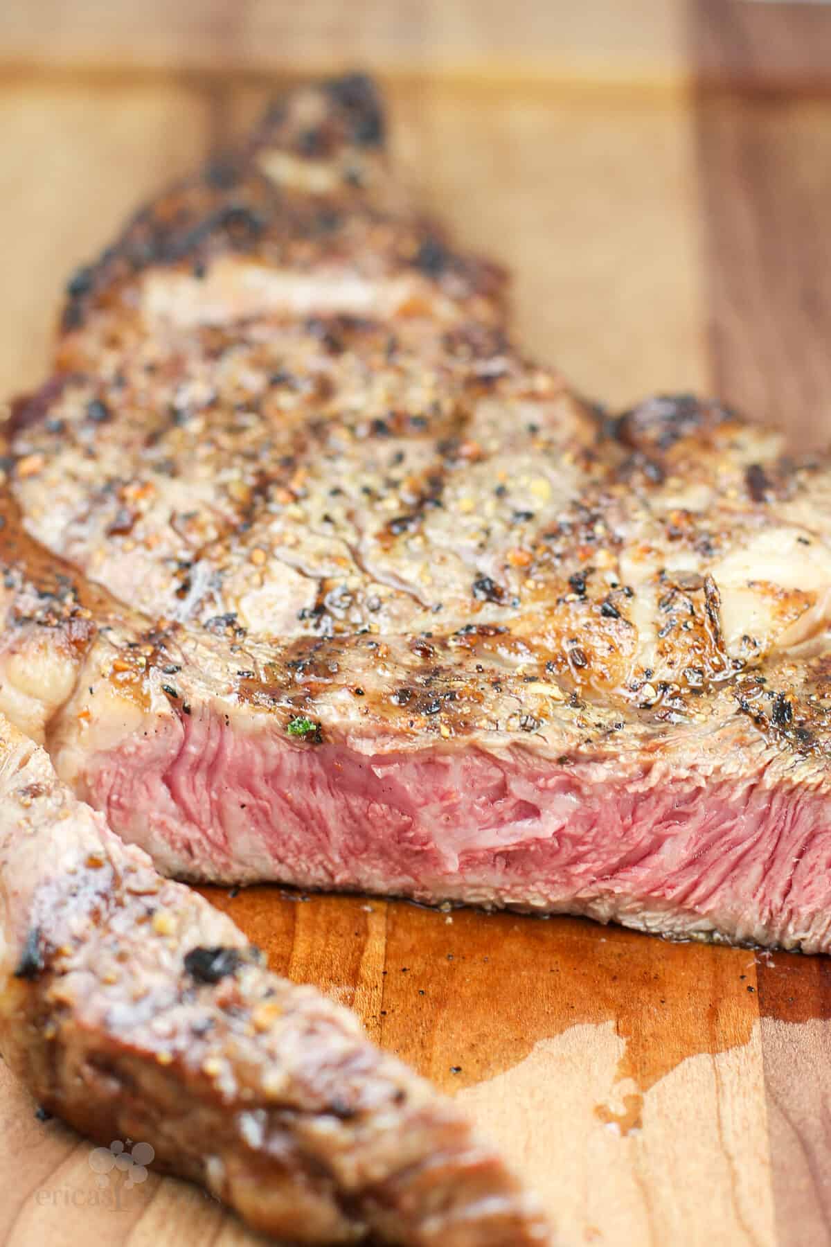 steak on wood board cut to show pink center