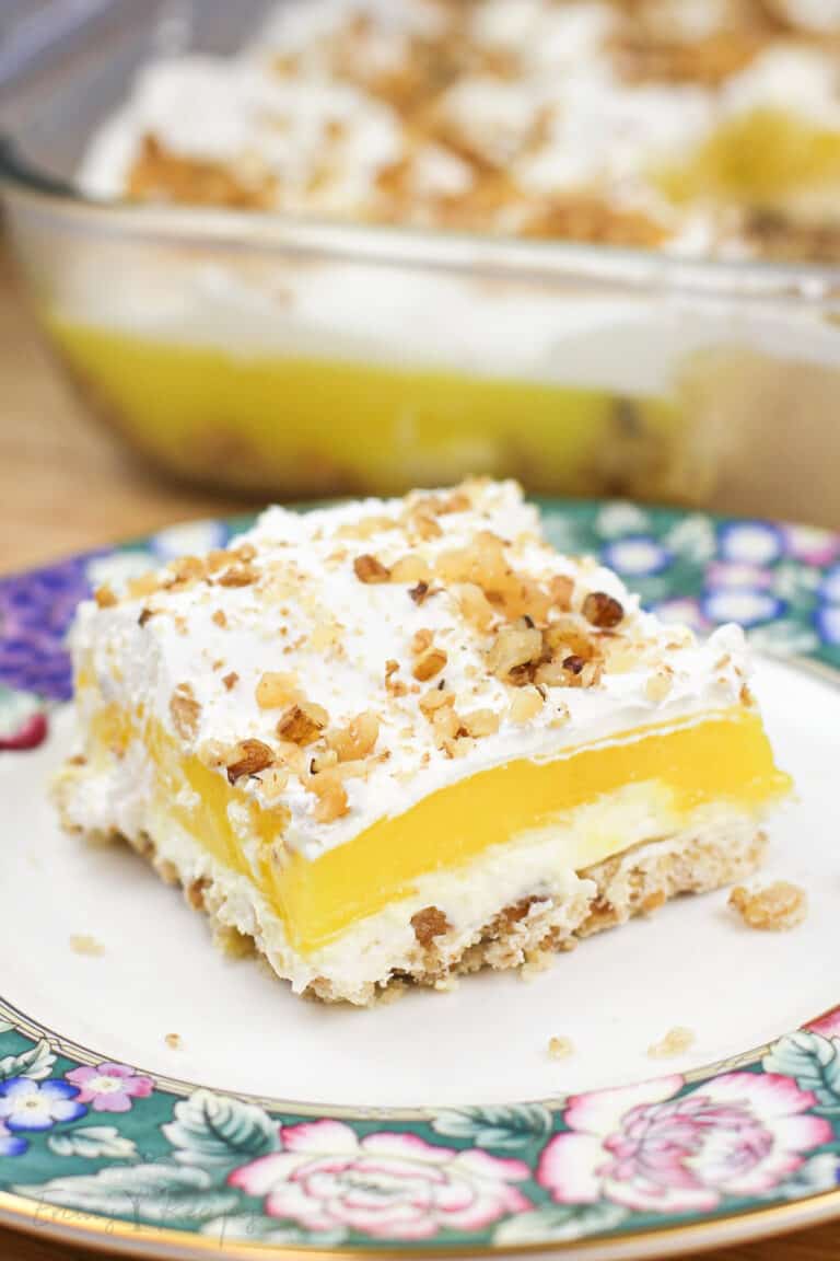 portion of Lemon Delight on floral dish; rest of dessert in dish in the background