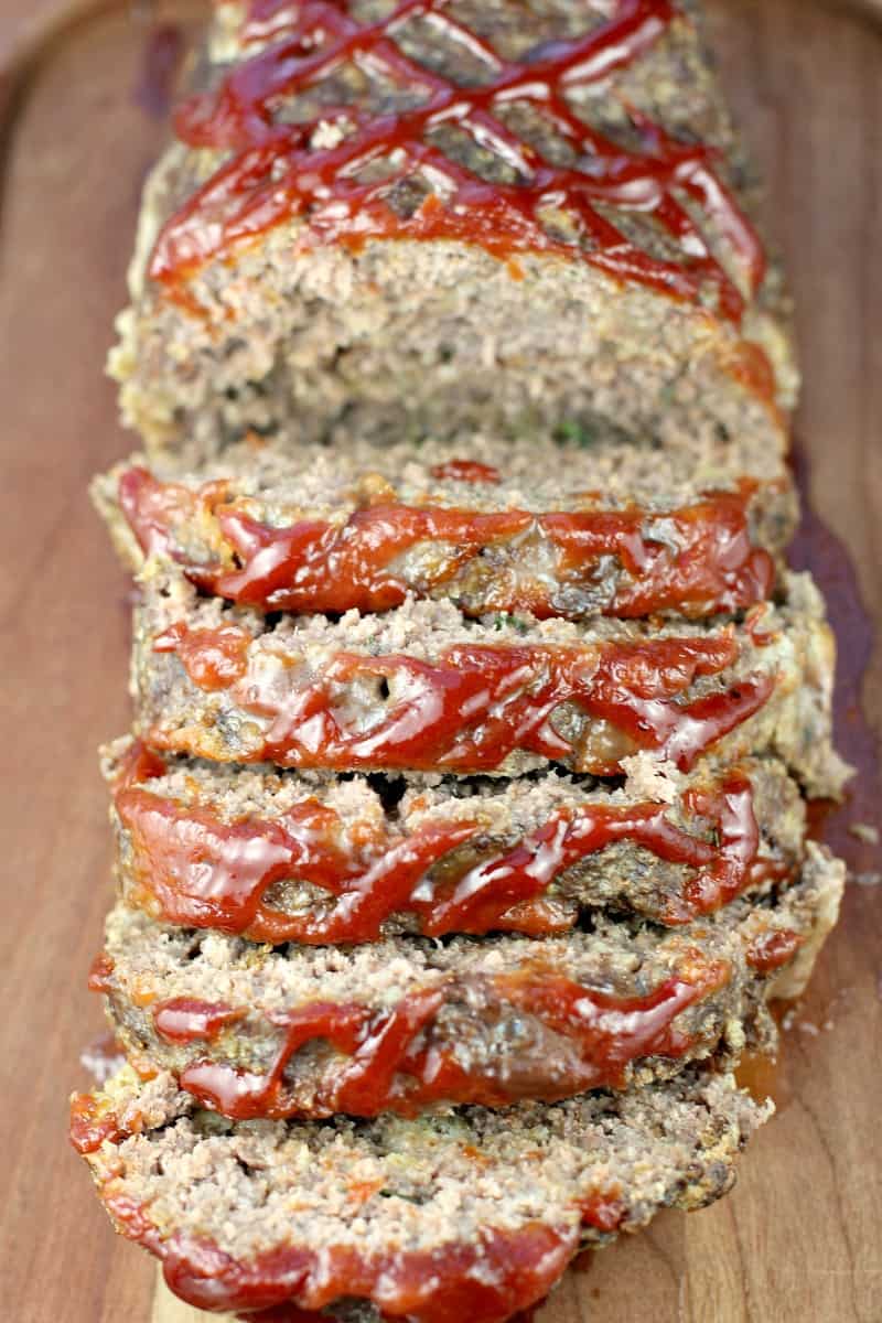 view of the sliced best meatloaf ever angled to show the ketchup and barbecue sauce on top