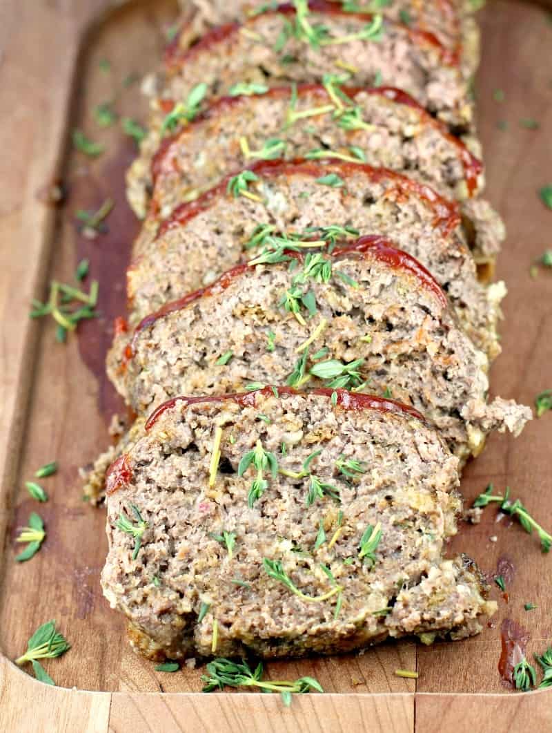 sliced mom's meatloaf layered on a wood board