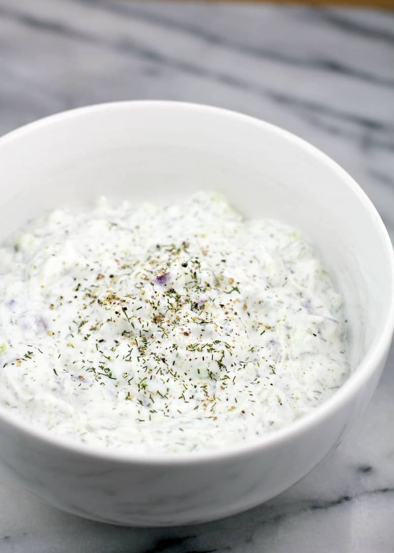 angled view of the Greek yogurt dip in a white bowl on white marble