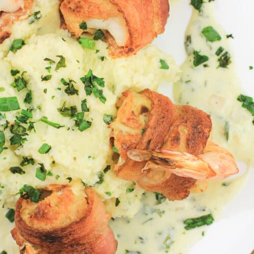 crab stuffed shrimp arranged around mashed potatoes on white plate