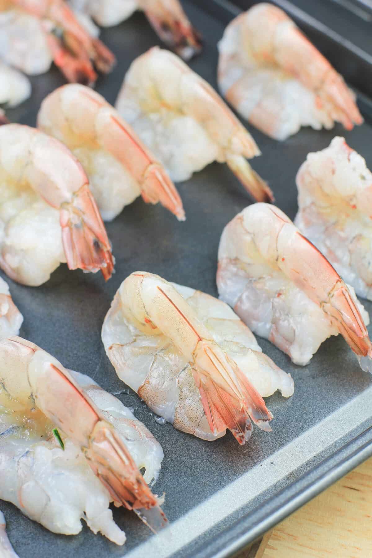 butterflied shrimp on bake sheet