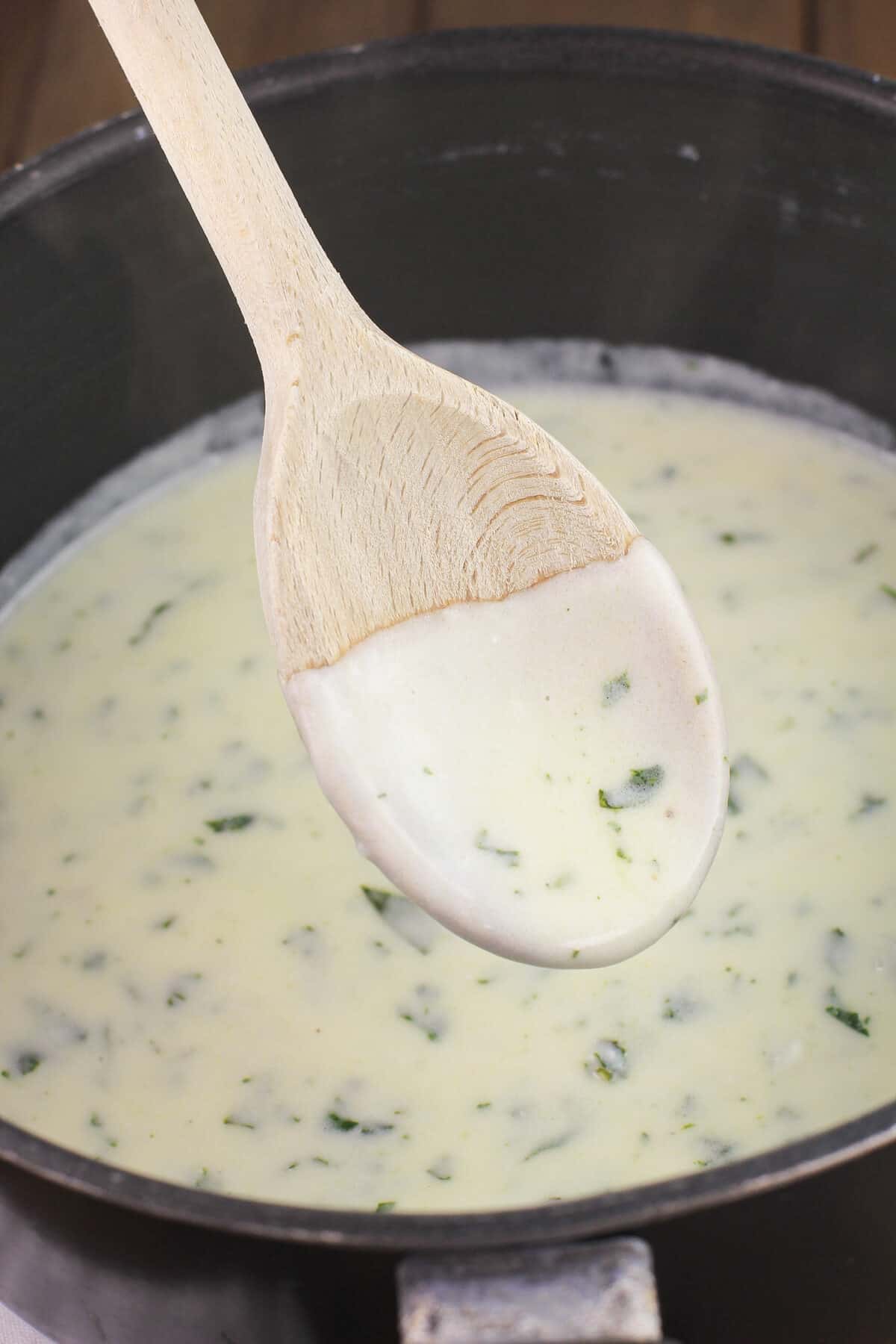 lemon basil cream on wooden spoon in saucepan