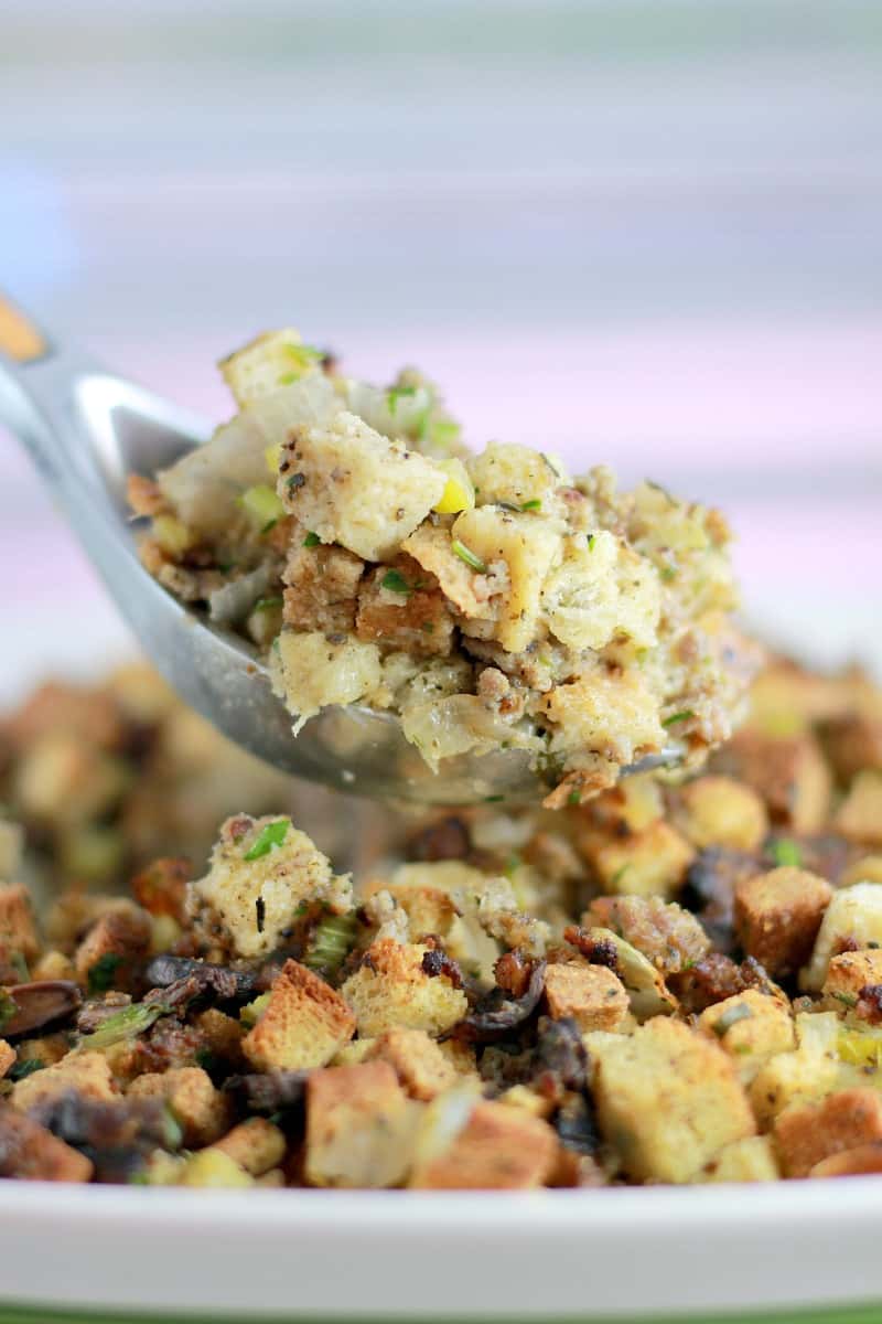 large silver spoon holding up a scoop of cooked stuffing