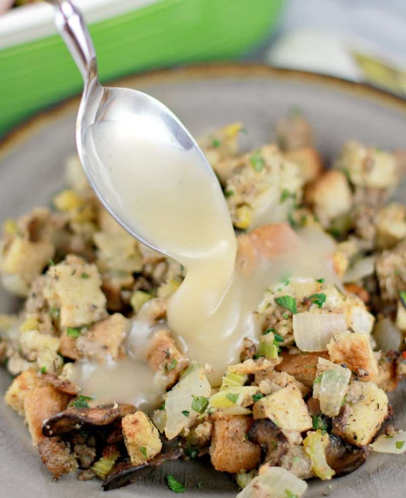 plated stuffing with a spoon drizzling gravy over top.