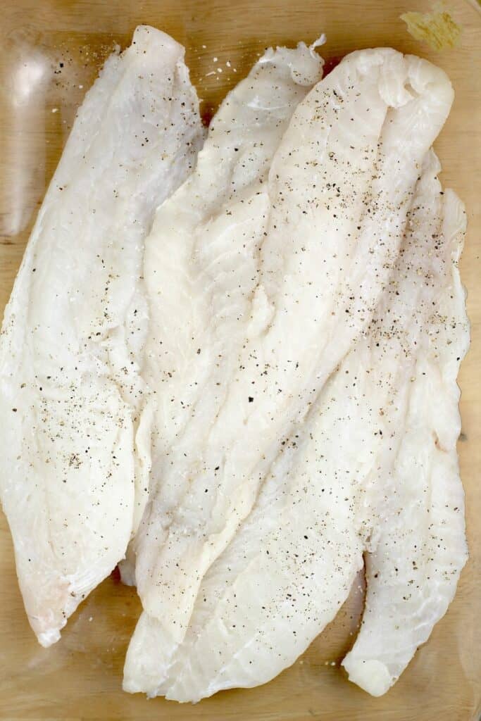 raw cod filets in a clear bake dish