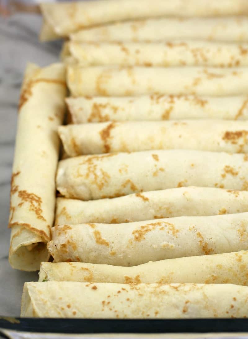 assembled crepes in a clear bake dish before cooking