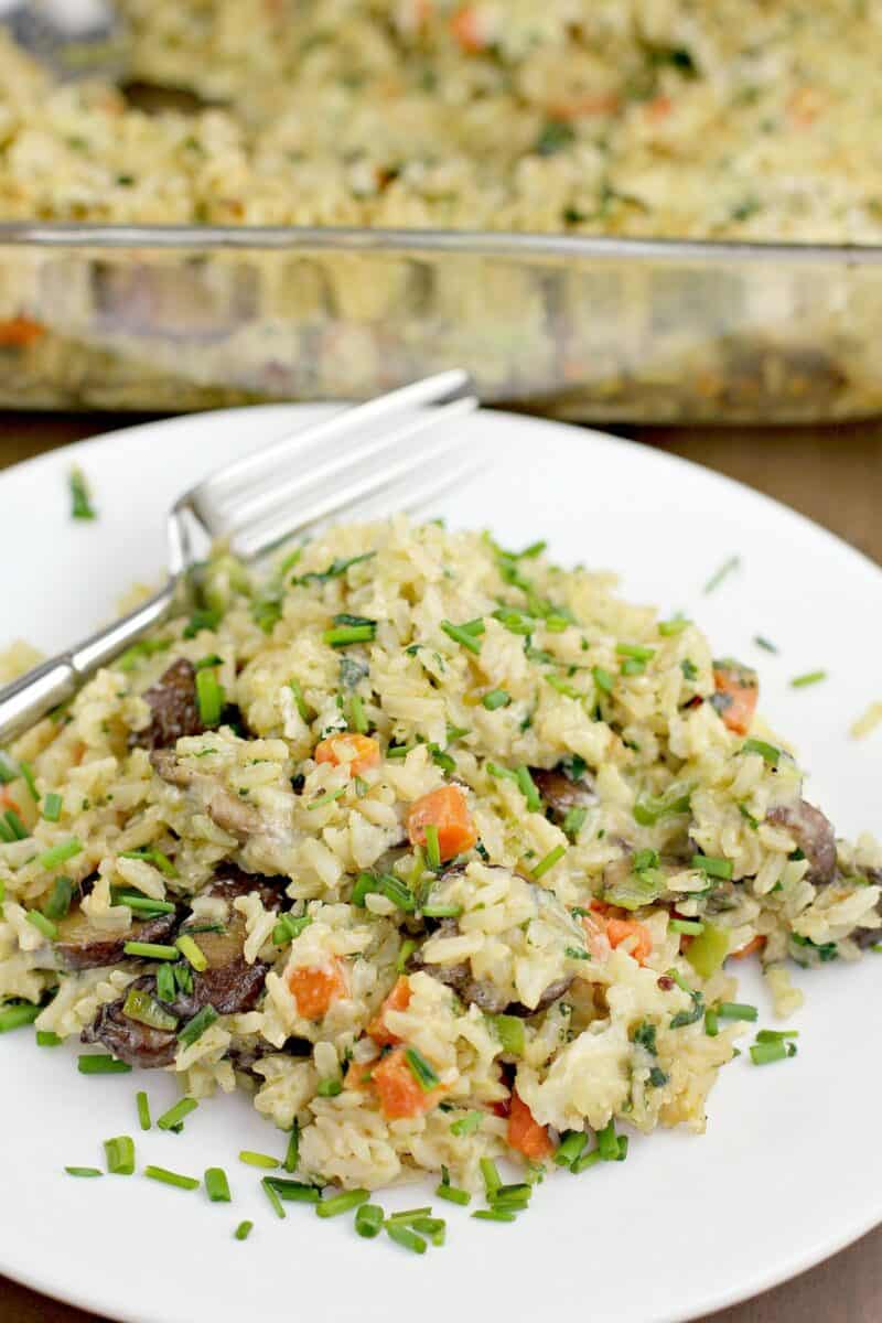 vegetarian rice casserole on a white plate with fork; bake dish in the back ground