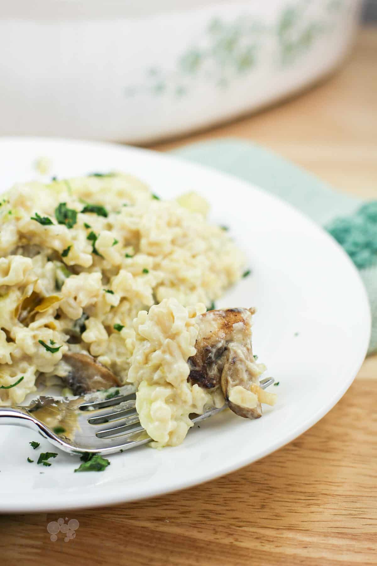 fork on white plate holding a bite-sized amount of rice casserole