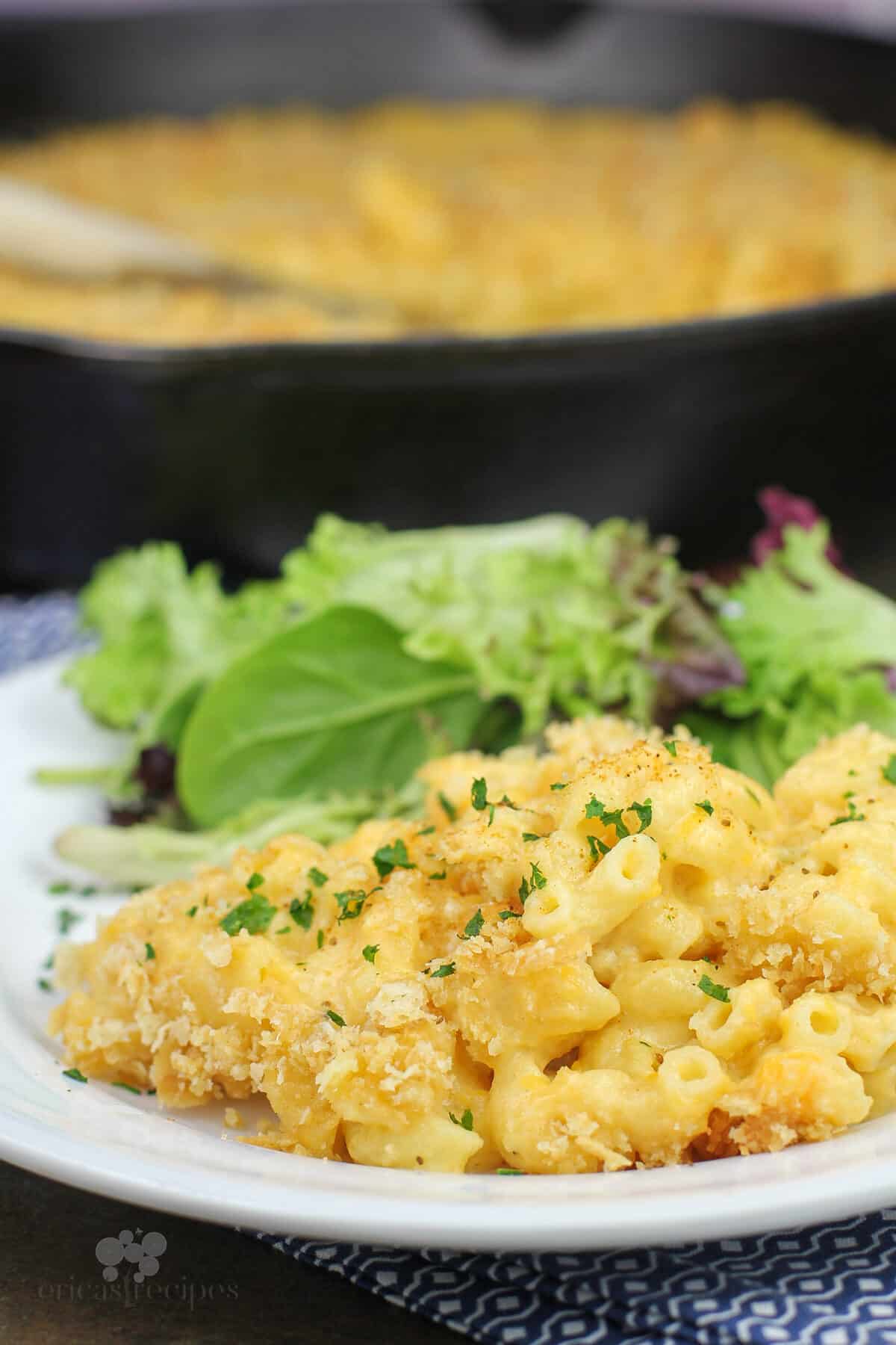 portion of macaroni and cheese on white plate with salad