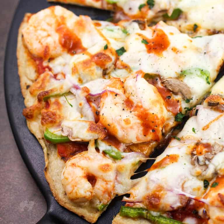 slice of cajun pizza on black surface
