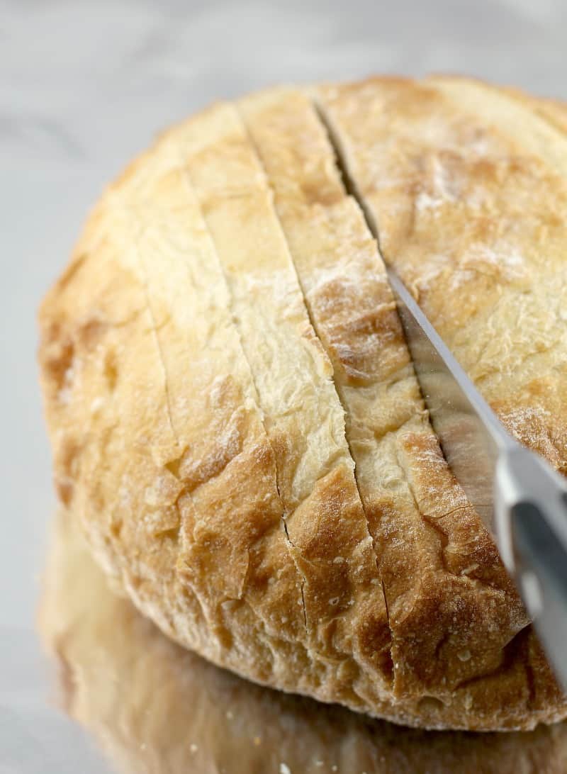 a bread knife cutting into the top of the bread loaf