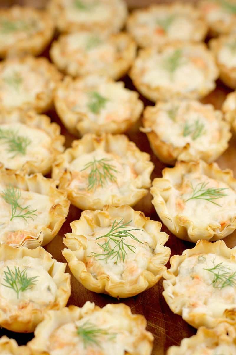 side view of a finished cold smoked salmon appetizer on a wood tray