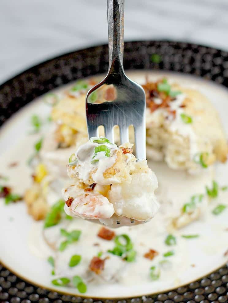 a fork holding shrimp and bit of biscuit