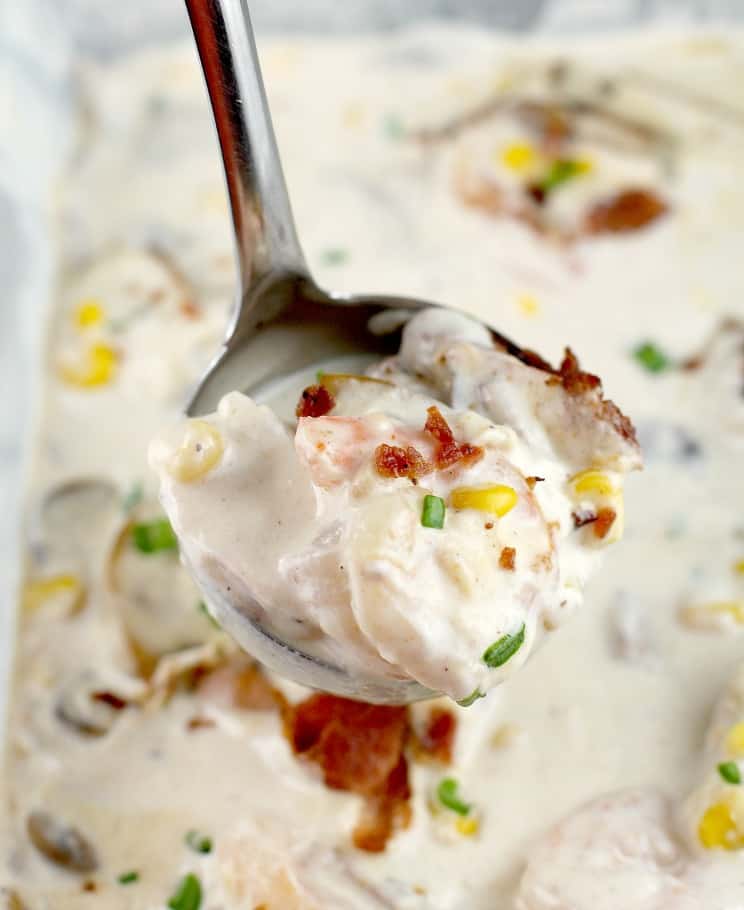 ladle filled with bacon, corn, and shrimp in cream gravy