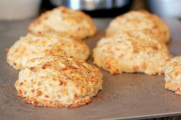 cooked bacon biscuits on metal bake sheet