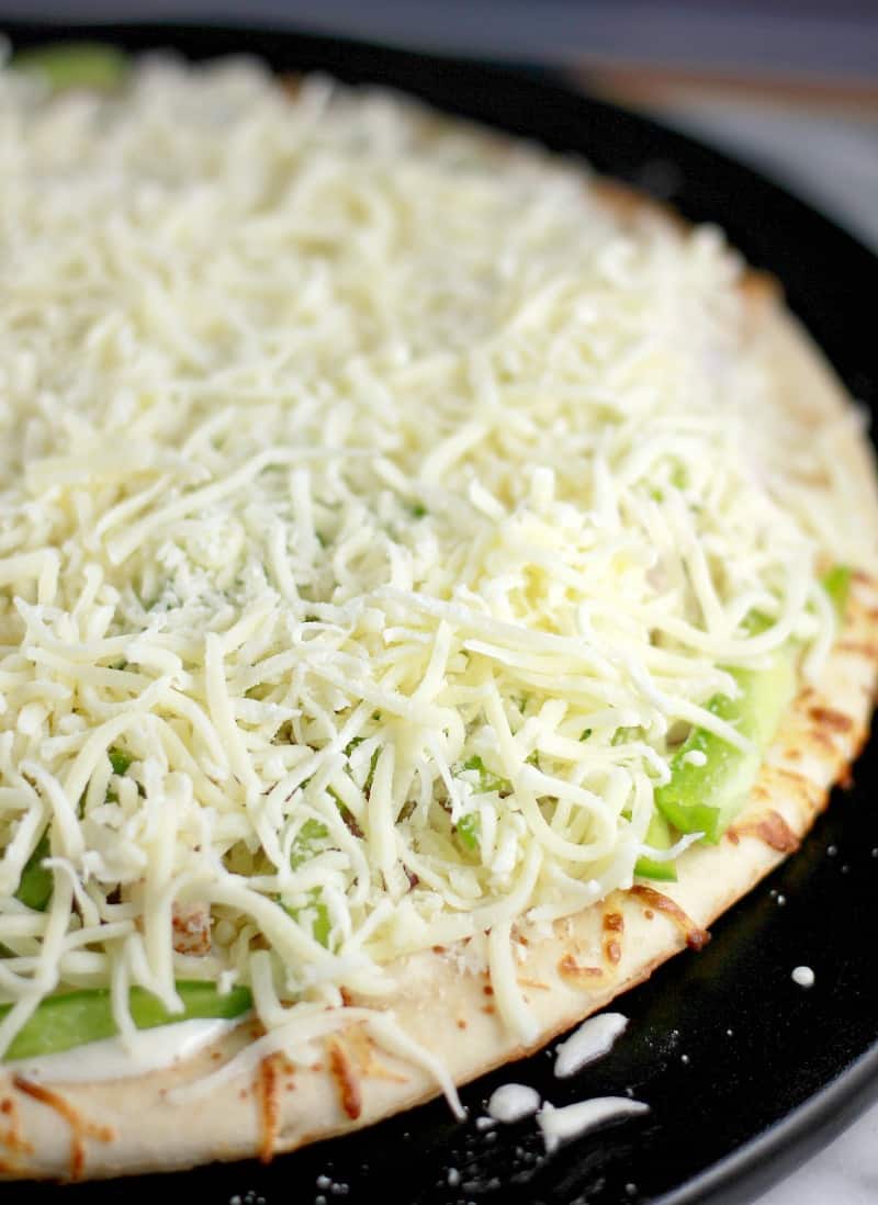 The uncooked pizza showing the layer of shredded mozzarella.