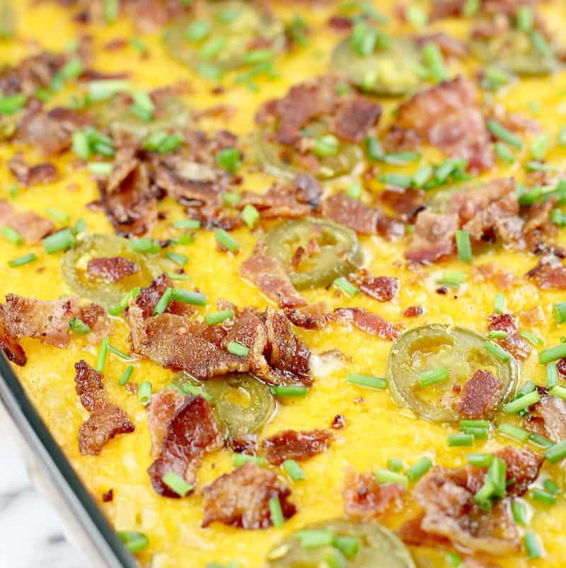 cooked casserole in bake dish topped with cheese, bacon, and jalapenos, close view