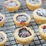 finished cherry cup cookies on a cooling rack over a marble board