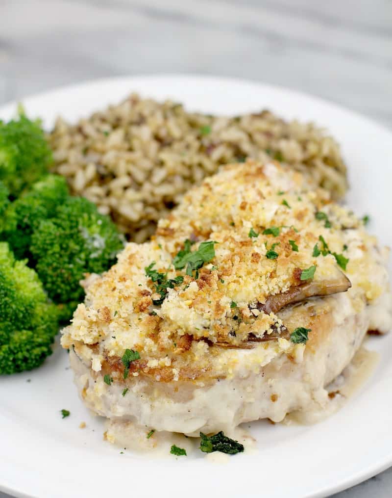 front view of finished pork plated on serving plate, rice and broccoli in the background