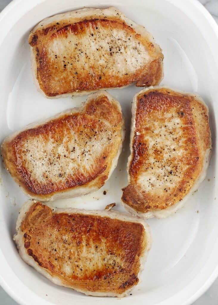 top view of seared boneless chops in a casserole dish