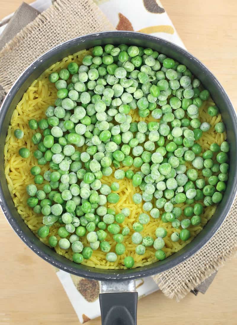 peas on cooked rice in a pot