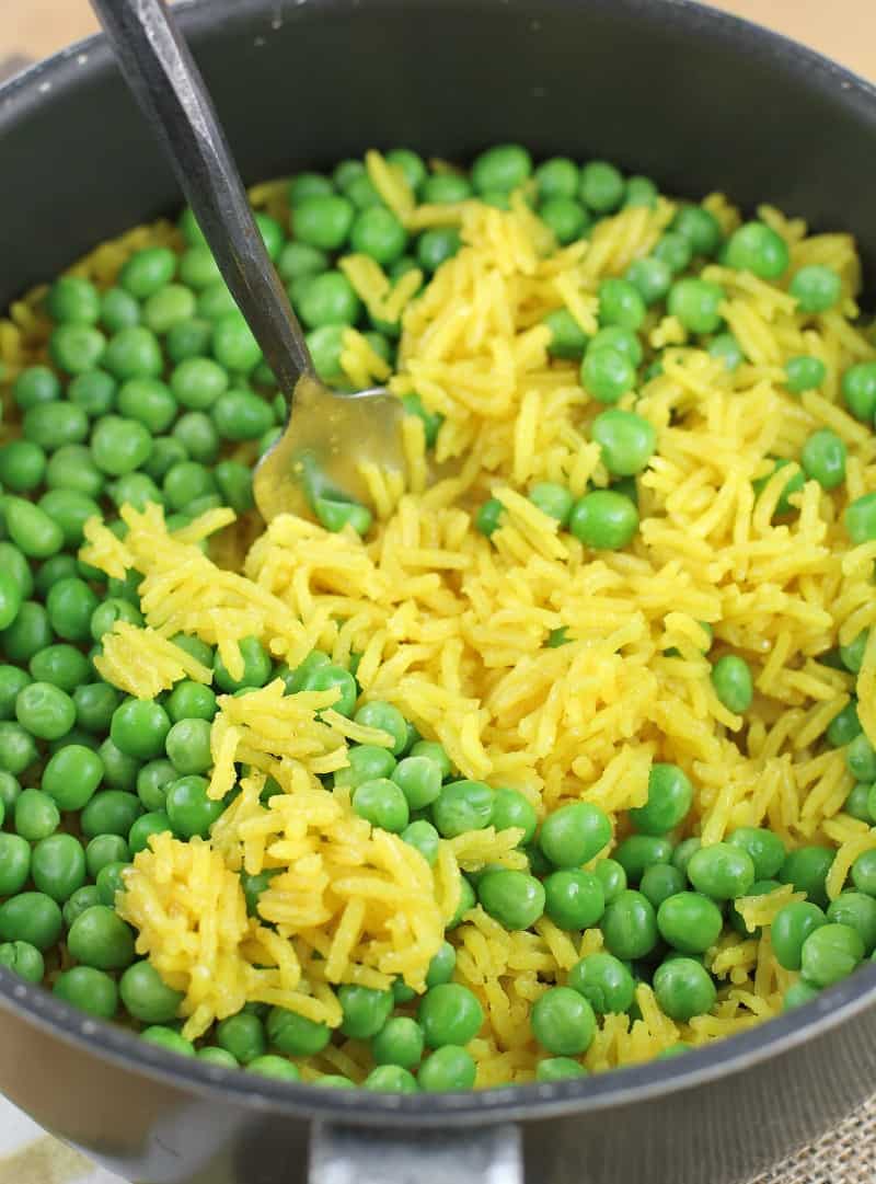 fork stirring peas into rice