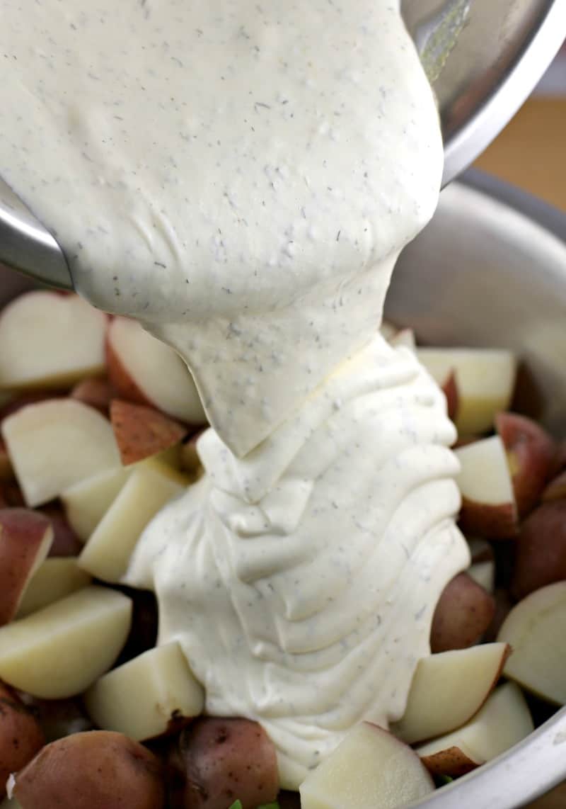 creamy white dressing pouring onto potatoes