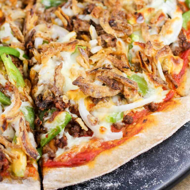 slice of chili cheeseburger pizza on pizza stone