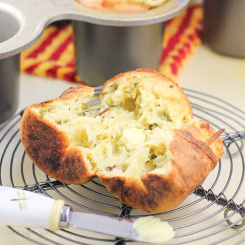 split poblano pepper popover on wire rack with small butter knife; popover pan in background