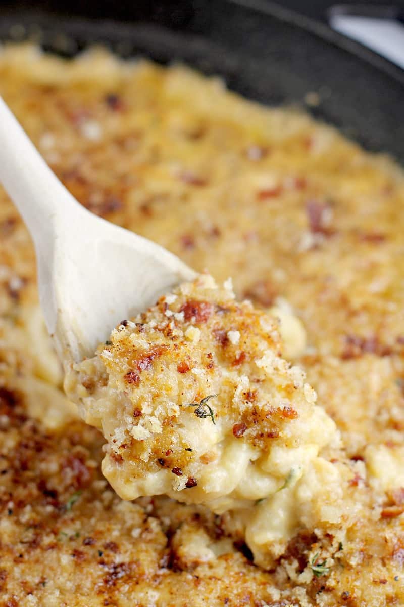 side view of a wooden spoon scooping up a bit of the beer mac and cheese