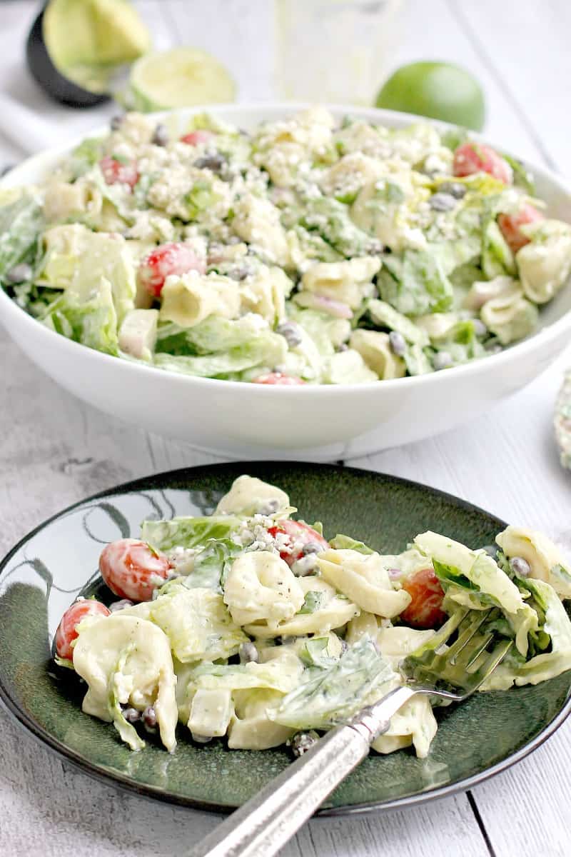 salad ingredients with a fork on a green plate