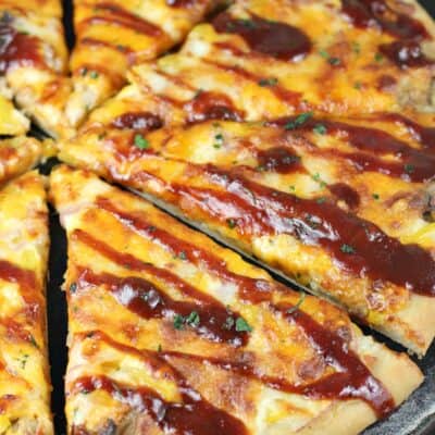 angled view of sliced Texas pizza drizzled with bbq sauce