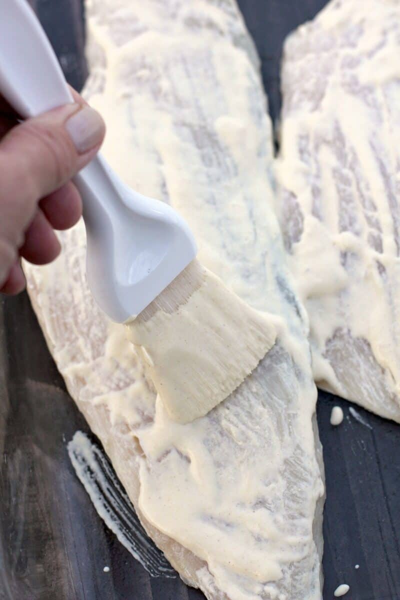 pastry brush brushing dijon-cream on haddock