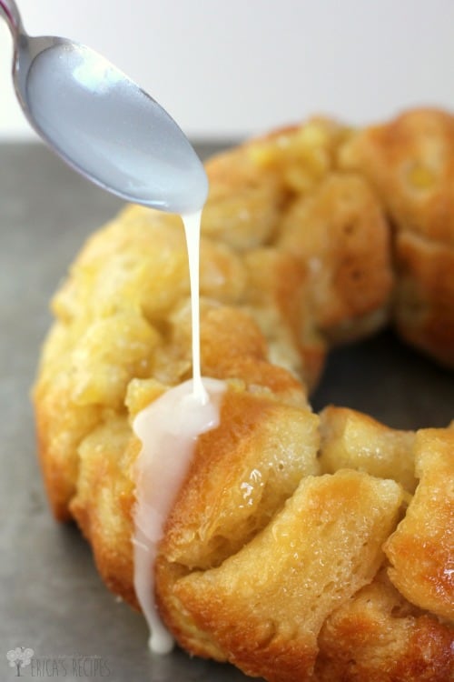 the cooked monkey bread with biscuits, a spoon is drizzling over the white glaze