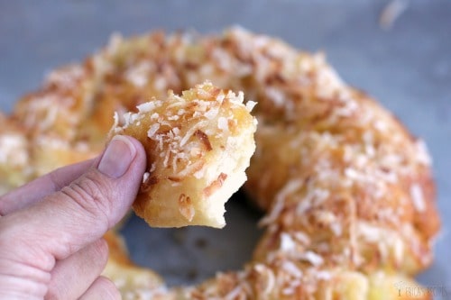 fingers holding up a piece of Monkey Bread with biscuits