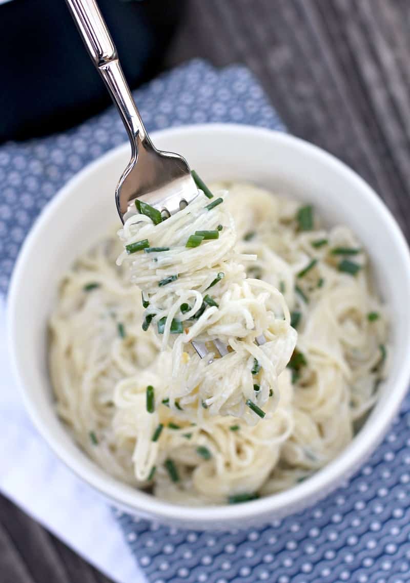 fork lifting up sour cream pasta from bowl