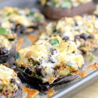 cooked mushrooms on a bake sheet topped with cheese