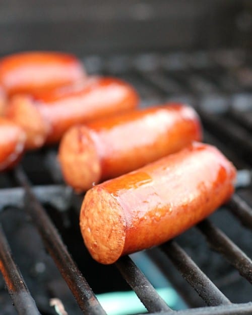 juicy beer brats cooking on the grill