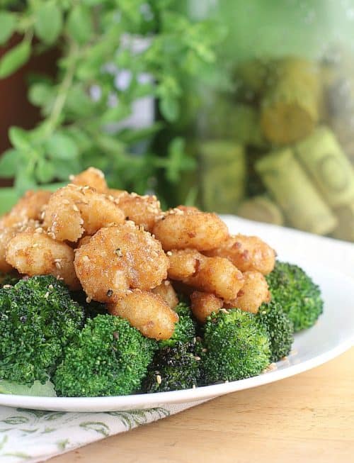 cooked sesame shrimp over broccoli on a white dish