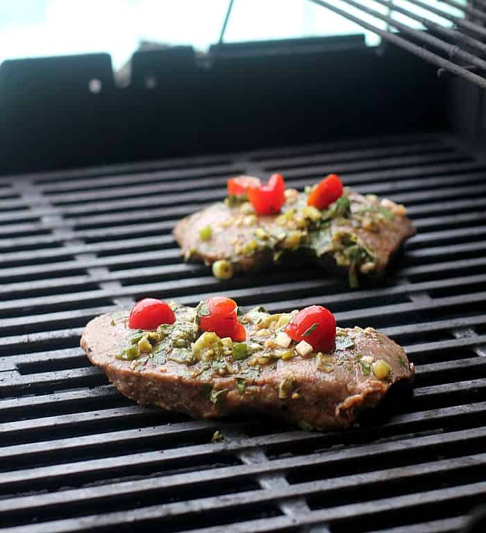 2 steaks cooking on a grill