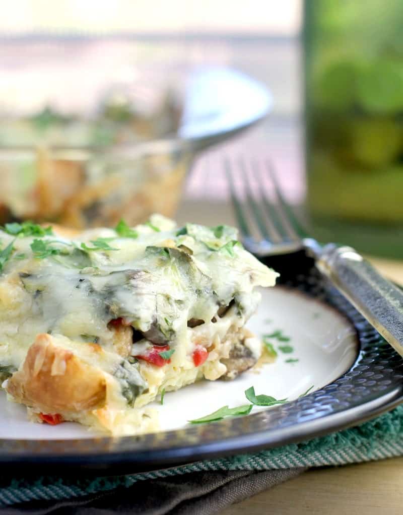 side view of plated croissant breakfast casserole showing the custard-like nature of this casserole