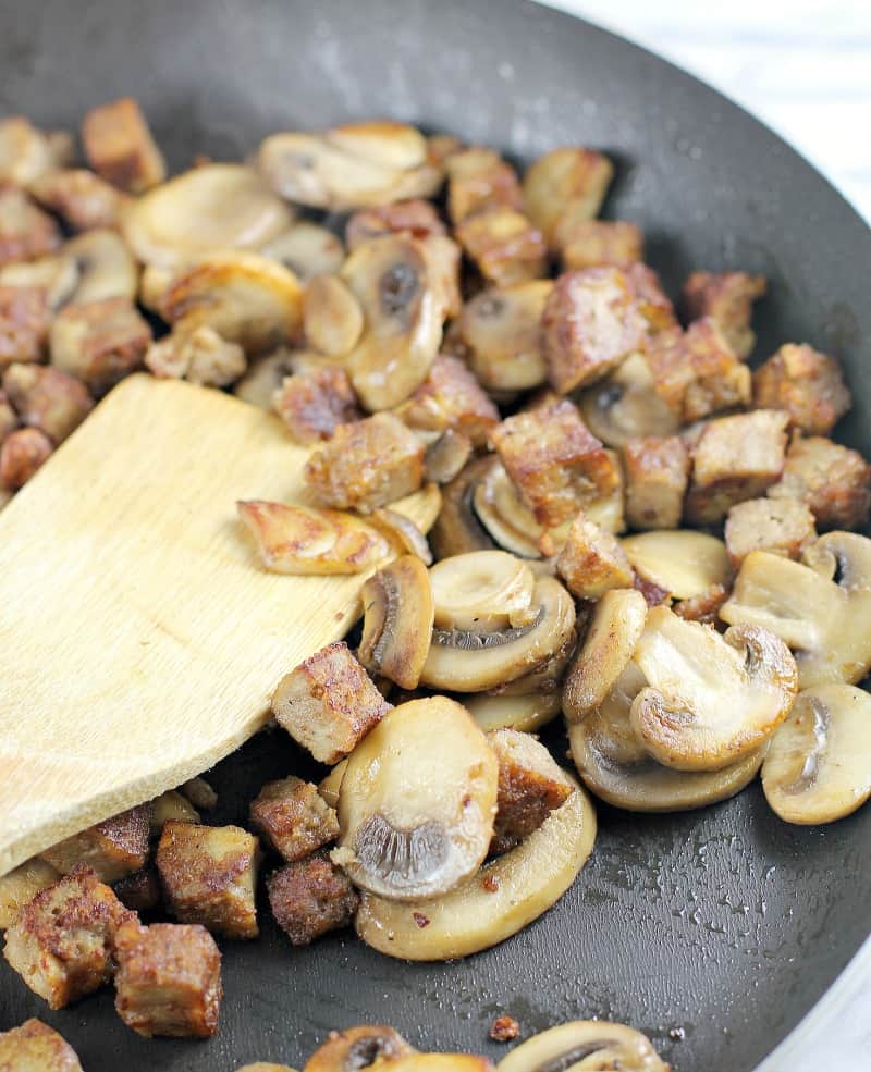 sauteed mushrooms and sausage in a skillet